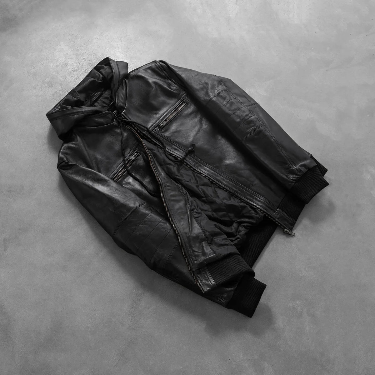 
Prospettiva indossata di Bouncer Biz Black Leather Hooded Bomber Jacket su modello - Drappeggio naturale alla luce del giorno